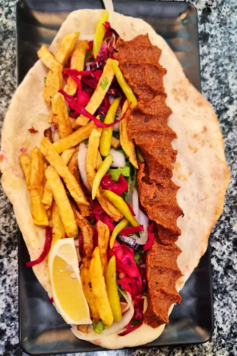 Pide üzerinde cevizli köfte, patates kızartması ve biber turşusu