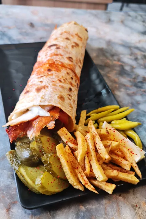 Tabakta zurna lavaş döner; yanında patates kızartması ve turşu